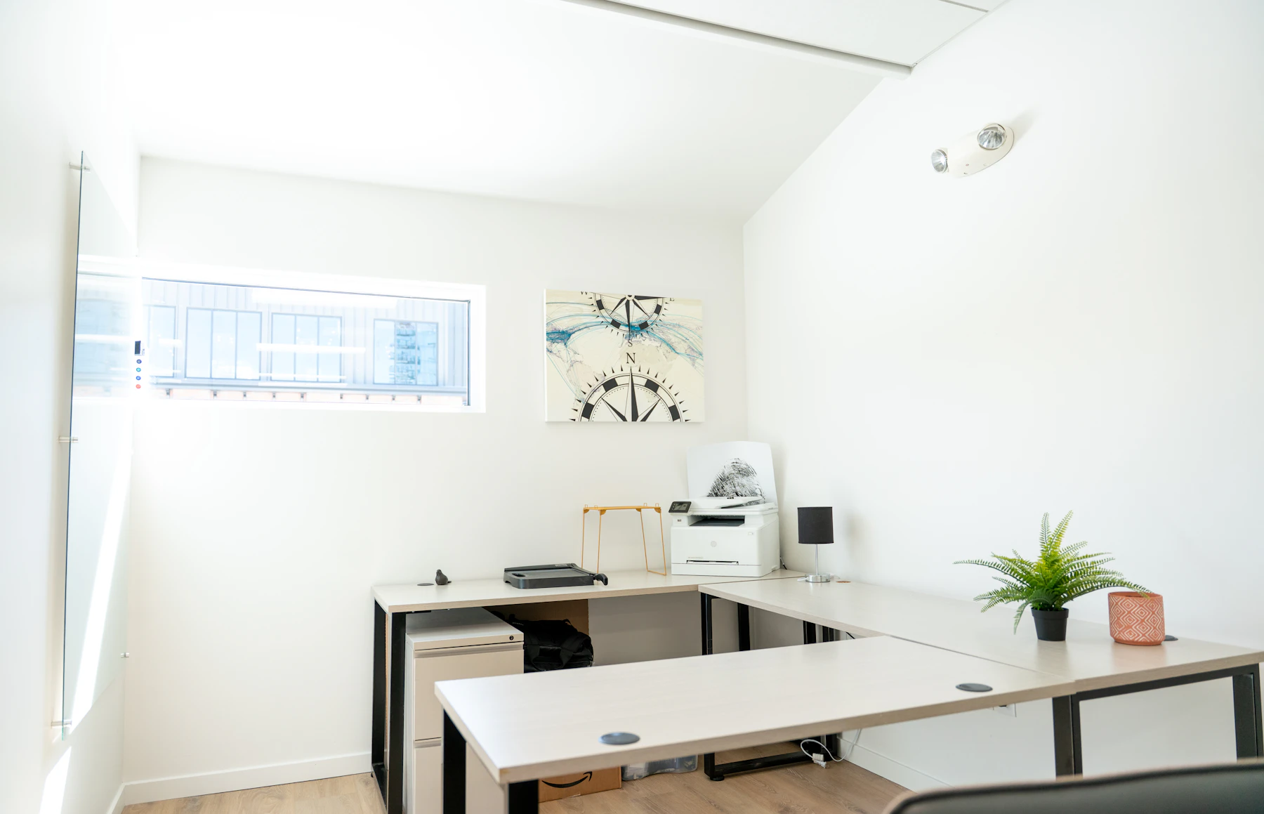 A quiet workspace with a wooden desk, plants, and natural light